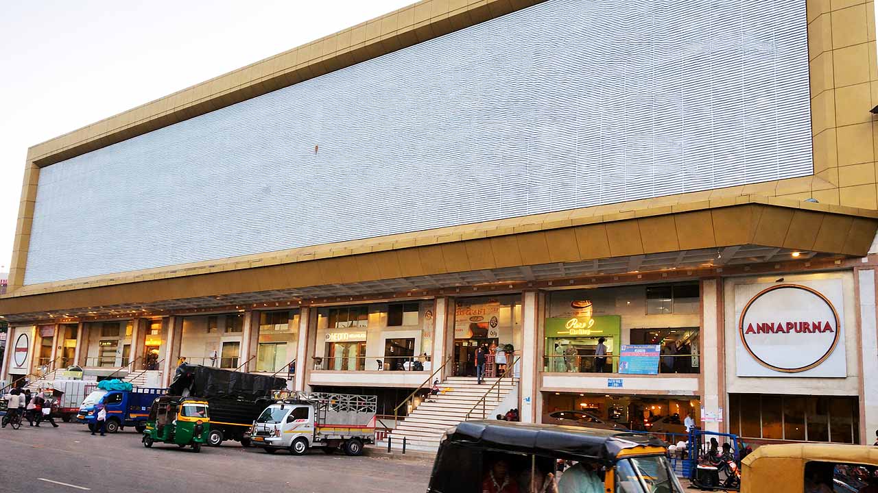 Front view of Annapurna Textile Market on Ring Road Surat showing large wholesale textile complex with shops and loading vehicles