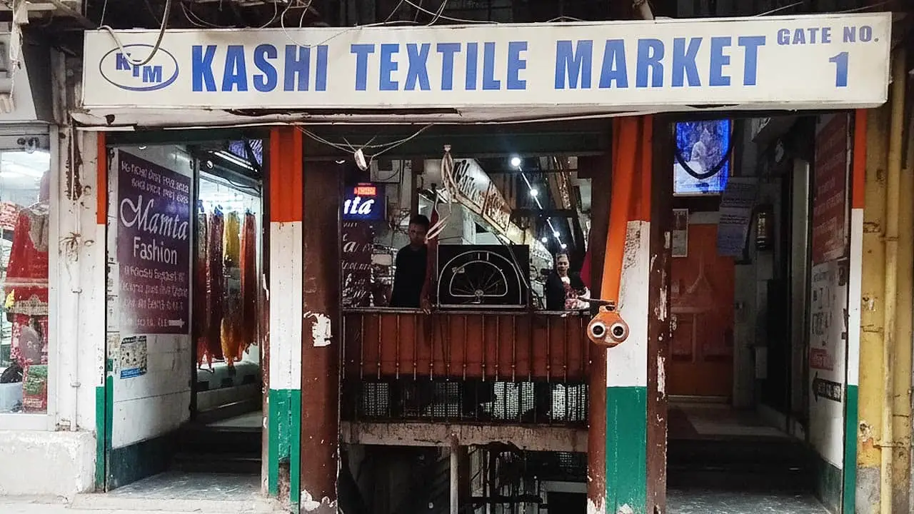 Close-up of the "KASHI TEXTILE MARKET" sign and Gate No. 1 at the entrance to the market in Surat, India.