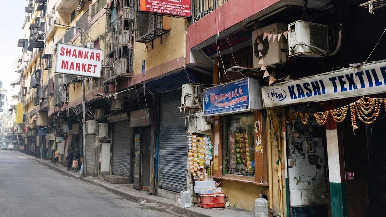 The visible sign for "SHANKAR MARKET" in red lettering on a white background, mounted on a multi-story building facade in Surat.
