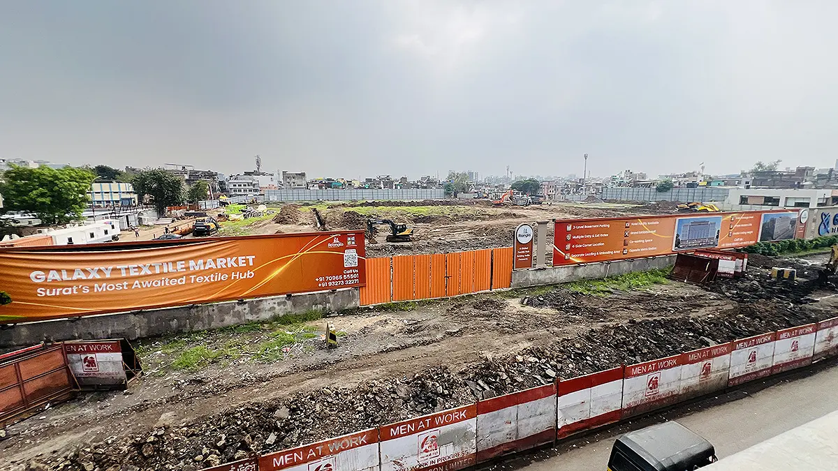 Galaxy Textile Market Surat construction site with JCB machines and project hoardings